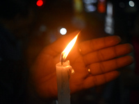 A woman is protecting a candle while protesting over the sexual assault and murder of a Kolkata woman doctor in Kolkata, India, on August 18...