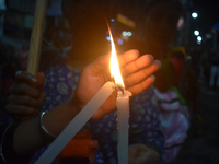 A woman is protecting a candle while protesting over the sexual assault and murder of a Kolkata woman doctor in Kolkata, India, on August 18...