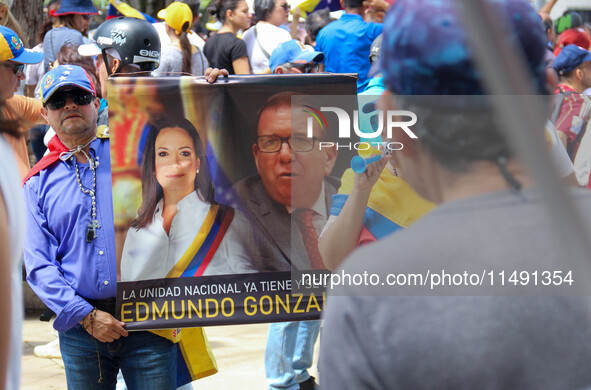 An activist is holding a banner with political phrases during a rally in downtown San Cristobal, Venezuela, on August 17, 2024. Citizens opp...