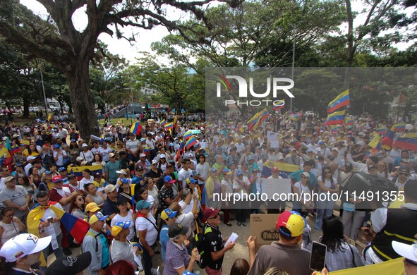 Several activists are holding banners and Venezuelan flags while gathering at a rally in Los Mangos square in San Cristobal, Venezuela, on A...