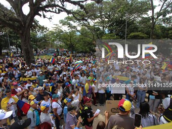 Several activists are holding banners and Venezuelan flags while gathering at a rally in Los Mangos square in San Cristobal, Venezuela, on A...