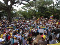 Several activists are holding banners and Venezuelan flags while gathering at a rally in Los Mangos square in San Cristobal, Venezuela, on A...