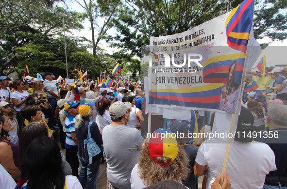 Several activists are holding banners and Venezuelan flags while gathering at a rally in Los Mangos square in San Cristobal, Venezuela, on A...