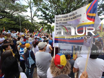 Several activists are holding banners and Venezuelan flags while gathering at a rally in Los Mangos square in San Cristobal, Venezuela, on A...