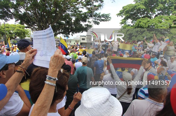 Several activists are holding banners and Venezuelan flags while gathering at a rally in Los Mangos square in San Cristobal, Venezuela, on A...