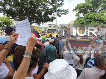 Several activists are holding banners and Venezuelan flags while gathering at a rally in Los Mangos square in San Cristobal, Venezuela, on A...