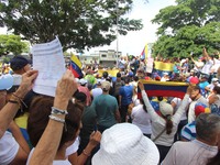 Several activists are holding banners and Venezuelan flags while gathering at a rally in Los Mangos square in San Cristobal, Venezuela, on A...