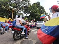 Several activists are holding banners and Venezuelan flags while gathering at a rally in Los Mangos square in San Cristobal, Venezuela, on A...