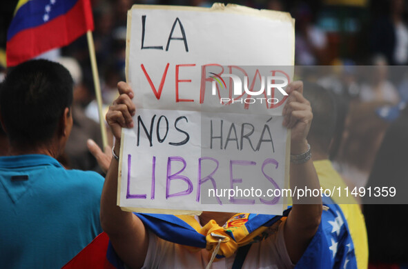 An activist is holding a banner with political phrases during a rally in downtown San Cristobal, Venezuela, on August 17, 2024. Citizens opp...