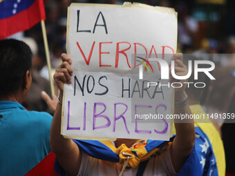 An activist is holding a banner with political phrases during a rally in downtown San Cristobal, Venezuela, on August 17, 2024. Citizens opp...