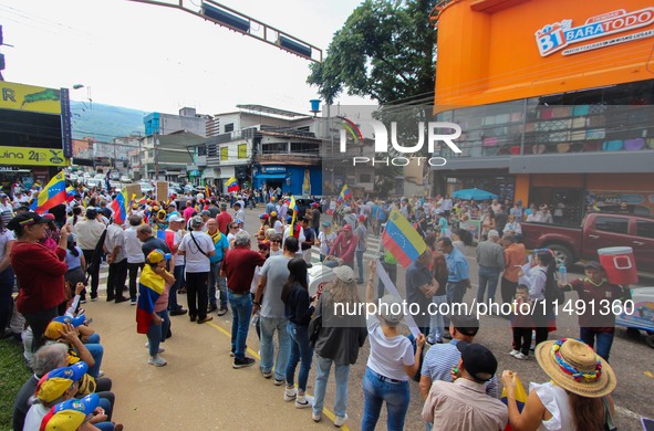 Several activists are holding banners and Venezuelan flags while gathering at a rally in Los Mangos square in San Cristobal, Venezuela, on A...