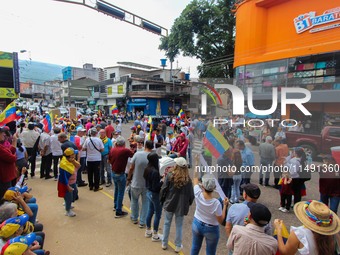 Several activists are holding banners and Venezuelan flags while gathering at a rally in Los Mangos square in San Cristobal, Venezuela, on A...