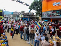 Several activists are holding banners and Venezuelan flags while gathering at a rally in Los Mangos square in San Cristobal, Venezuela, on A...