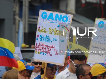 An activist is holding a banner with political phrases during a rally in downtown San Cristobal, Venezuela, on August 17, 2024. Citizens opp...