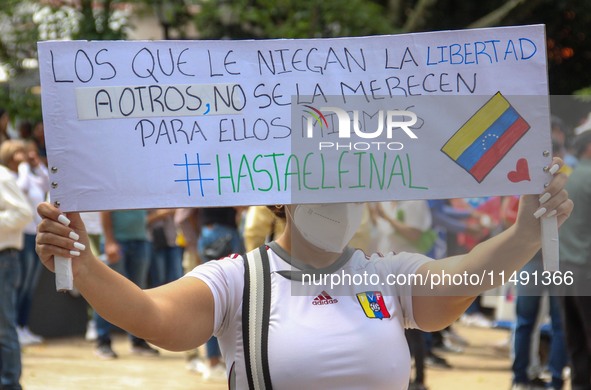 An activist is holding a banner with political phrases during a rally in downtown San Cristobal, Venezuela, on August 17, 2024. Citizens opp...