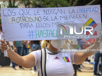 An activist is holding a banner with political phrases during a rally in downtown San Cristobal, Venezuela, on August 17, 2024. Citizens opp...