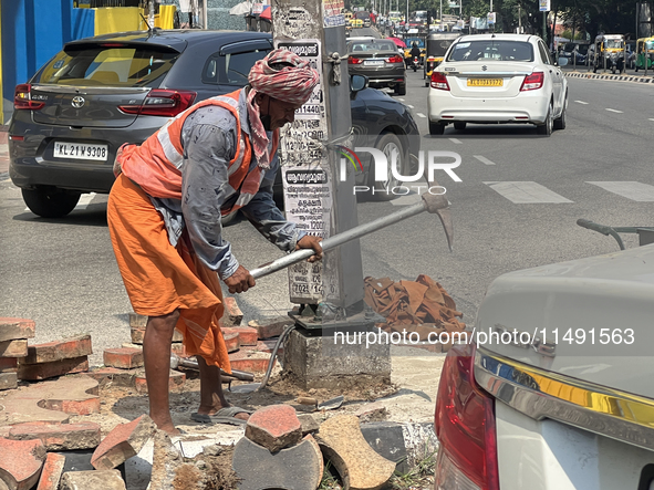 A worker is using a pick-axe while doing road construction in Thiruvananthapuram (Trivandrum), Kerala, India, on April 08, 2024. 