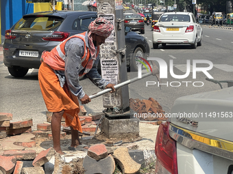 A worker is using a pick-axe while doing road construction in Thiruvananthapuram (Trivandrum), Kerala, India, on April 08, 2024. (