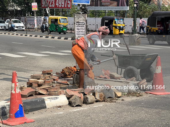 A worker is using a pick-axe while doing road construction in Thiruvananthapuram (Trivandrum), Kerala, India, on April 08, 2024. 