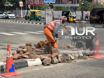 A worker is using a pick-axe while doing road construction in Thiruvananthapuram (Trivandrum), Kerala, India, on April 08, 2024. (