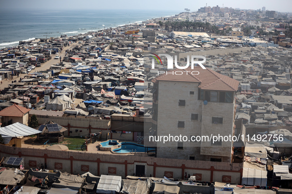 Displaced Palestinians, who are fleeing their house due to Israeli strikes, are sheltering at a tent camp amid the ongoing conflict between...