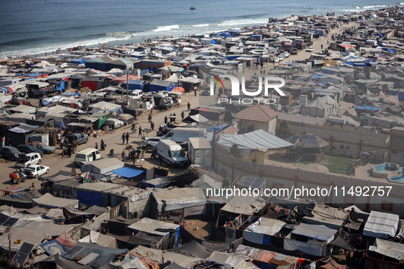 Displaced Palestinians, who are fleeing their house due to Israeli strikes, are sheltering at a tent camp amid the ongoing conflict between...