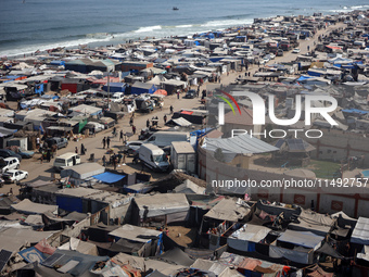 Displaced Palestinians, who are fleeing their house due to Israeli strikes, are sheltering at a tent camp amid the ongoing conflict between...