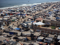 Displaced Palestinians, who are fleeing their house due to Israeli strikes, are sheltering at a tent camp amid the ongoing conflict between...