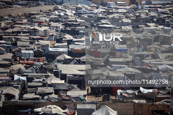 Displaced Palestinians, who are fleeing their house due to Israeli strikes, are sheltering at a tent camp amid the ongoing conflict between...