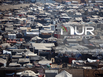 Displaced Palestinians, who are fleeing their house due to Israeli strikes, are sheltering at a tent camp amid the ongoing conflict between...