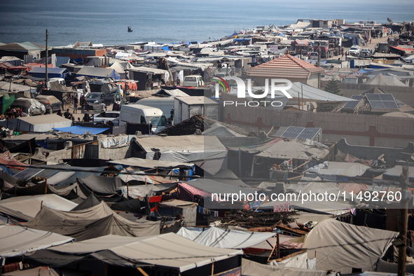 Displaced Palestinians, who are fleeing their house due to Israeli strikes, are sheltering at a tent camp amid the ongoing conflict between...