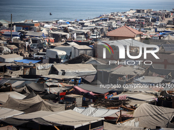 Displaced Palestinians, who are fleeing their house due to Israeli strikes, are sheltering at a tent camp amid the ongoing conflict between...