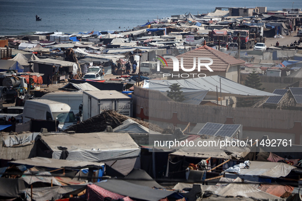 Displaced Palestinians, who are fleeing their house due to Israeli strikes, are sheltering at a tent camp amid the ongoing conflict between...