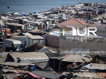 Displaced Palestinians, who are fleeing their house due to Israeli strikes, are sheltering at a tent camp amid the ongoing conflict between...