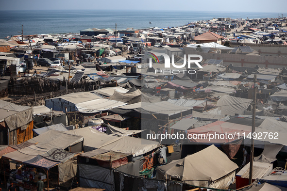 Displaced Palestinians, who are fleeing their house due to Israeli strikes, are sheltering at a tent camp amid the ongoing conflict between...