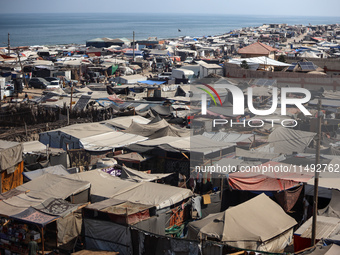 Displaced Palestinians, who are fleeing their house due to Israeli strikes, are sheltering at a tent camp amid the ongoing conflict between...