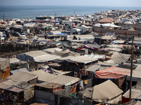 Displaced Palestinians, who are fleeing their house due to Israeli strikes, are sheltering at a tent camp amid the ongoing conflict between...