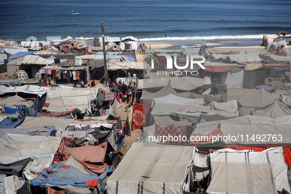 Displaced Palestinians, who are fleeing their house due to Israeli strikes, are sheltering at a tent camp amid the ongoing conflict between...