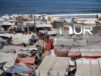 Displaced Palestinians, who are fleeing their house due to Israeli strikes, are sheltering at a tent camp amid the ongoing conflict between...