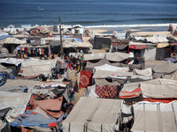 Displaced Palestinians, who are fleeing their house due to Israeli strikes, are sheltering at a tent camp amid the ongoing conflict between...