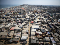 Displaced Palestinians, who are fleeing their house due to Israeli strikes, are sheltering at a tent camp amid the ongoing conflict between...