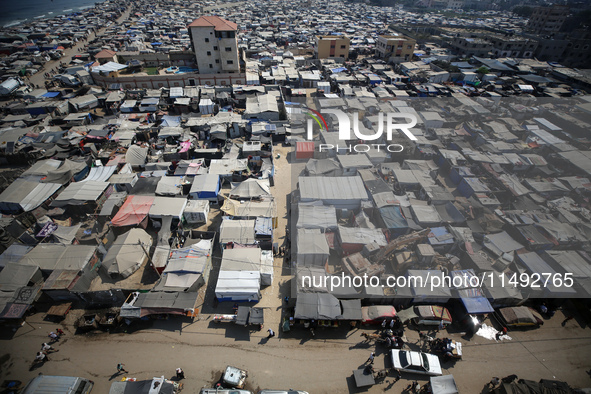 Displaced Palestinians, who are fleeing their house due to Israeli strikes, are sheltering at a tent camp amid the ongoing conflict between...