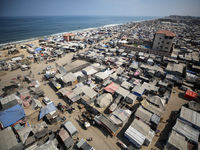 Displaced Palestinians, who are fleeing their house due to Israeli strikes, are sheltering at a tent camp amid the ongoing conflict between...