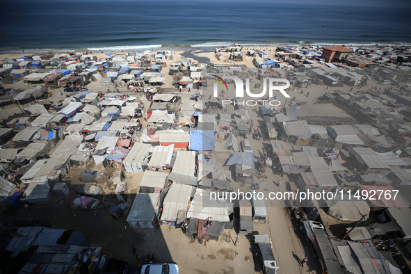 Displaced Palestinians, who are fleeing their house due to Israeli strikes, are sheltering at a tent camp amid the ongoing conflict between...