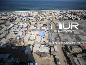 Displaced Palestinians, who are fleeing their house due to Israeli strikes, are sheltering at a tent camp amid the ongoing conflict between...