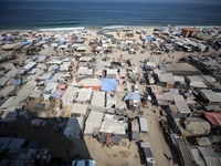 Displaced Palestinians, who are fleeing their house due to Israeli strikes, are sheltering at a tent camp amid the ongoing conflict between...