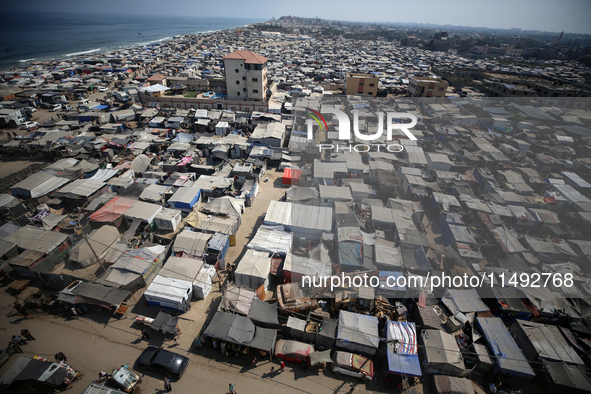 Displaced Palestinians, who are fleeing their house due to Israeli strikes, are sheltering at a tent camp amid the ongoing conflict between...