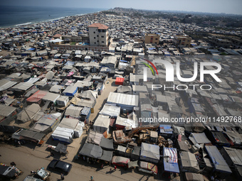 Displaced Palestinians, who are fleeing their house due to Israeli strikes, are sheltering at a tent camp amid the ongoing conflict between...