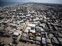 Displaced Palestinians, who are fleeing their house due to Israeli strikes, are sheltering at a tent camp amid the ongoing conflict between...