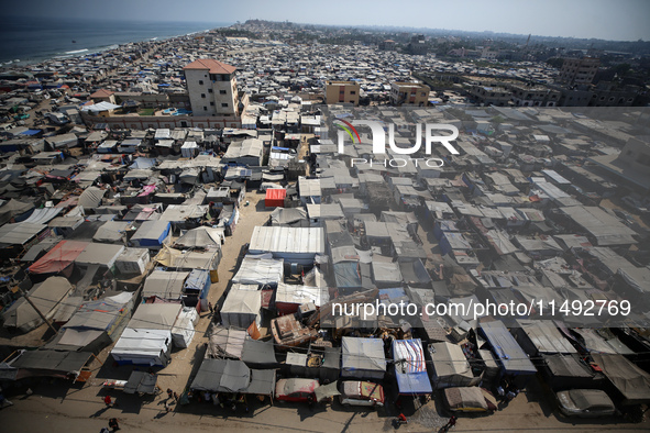 Displaced Palestinians, who are fleeing their house due to Israeli strikes, are sheltering at a tent camp amid the ongoing conflict between...